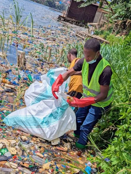 Collecting plastic bottles on a Lake Kivu shore.